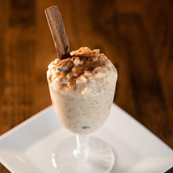 Arroz con Leche, a Cuban rice pudding, topped with cinnamon powder and a cinnamon stick.