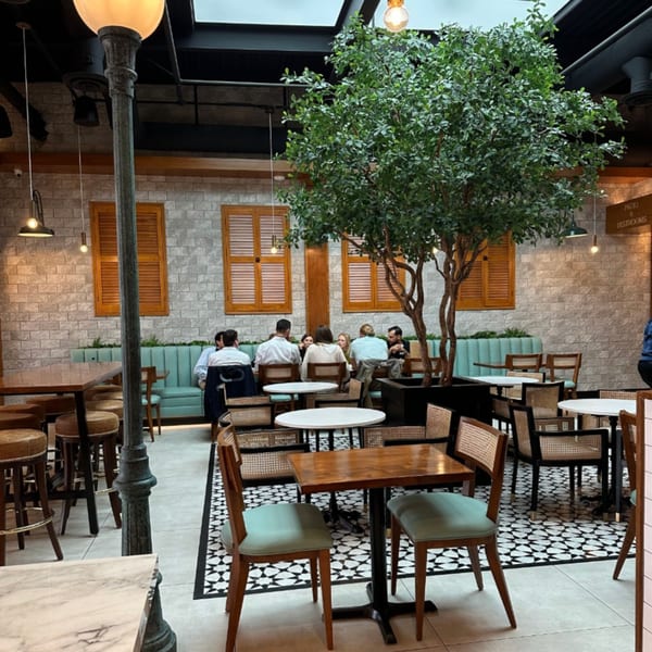 Havana Grill's dining area with patrons, a large tree, and patterned floor tiles.