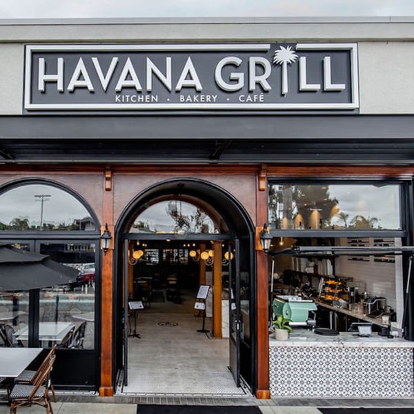 Exterior of Havana Grill, a Cuban restaurant, with its sign, arched entrance, and outdoor seating.